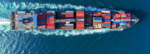 Aerial view Top speed with beautiful wave of container ship full load container with crane loading container for logistics import export or transportation concept background