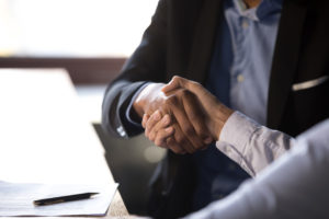 Close up african businessman shaking hands with client