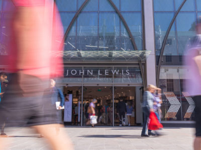 Busy Shoppers in the centre of Cheltenham in The Cotswolds, walking past the new John Lewis & Partners store in the High Street