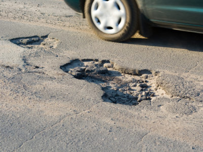 Asphalt`s holes on roadbed. Car in a motion.