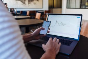 A person viewing the same graph on a mobile and laptop screen