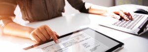 Close-up Of A Busineswoman's Hand Working With Invoice On Digital Tablet - Tungsten Network