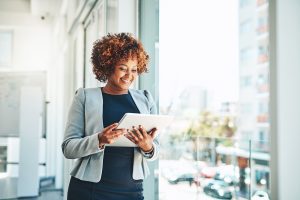 A women reading over a trending topics report walking through a sunny office